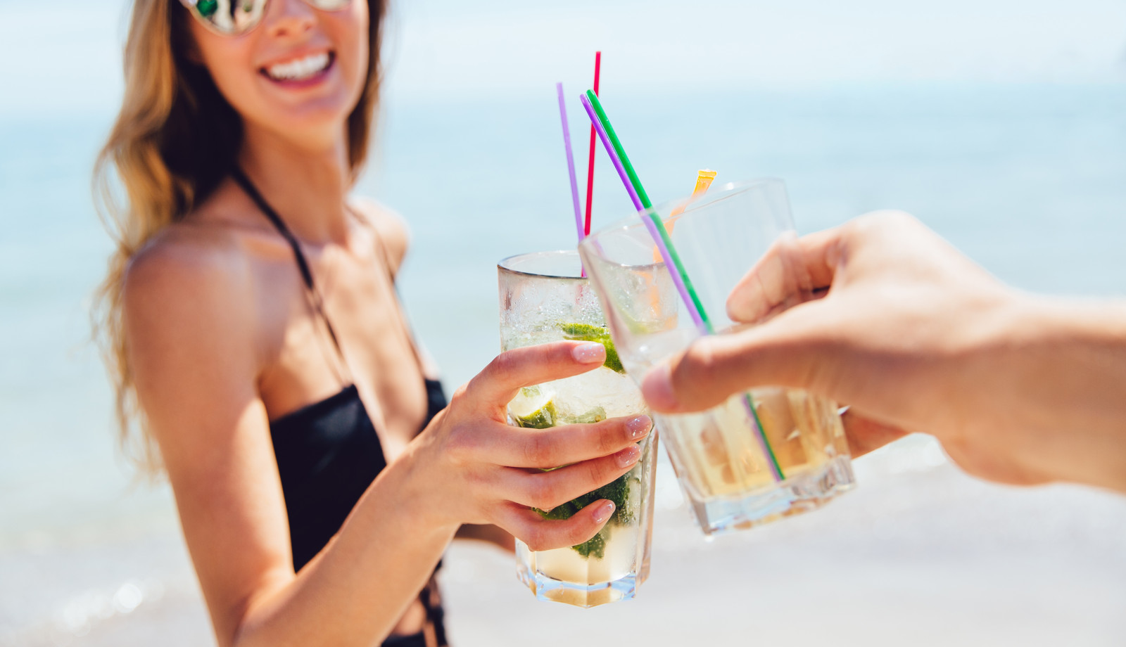media.donna-attraente-allegra-in-occhiali-da-sole-che-beve-un-cocktail-con-amico-tostatura